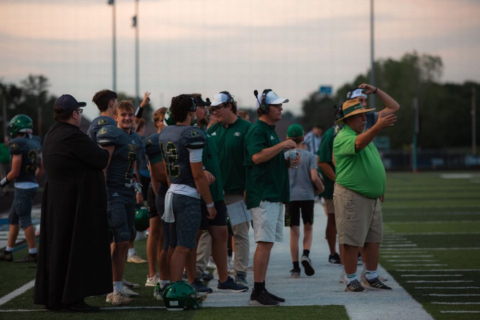 Coaches and players on high school football sidelines during a game. Coaches and players on high school football sidelines during a game.
