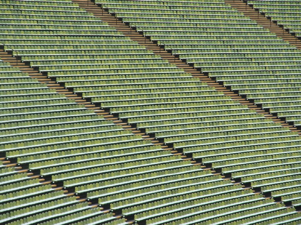 Rows of empty green stadium seats creating a symmetrical pattern in Munich, Germany. Rows of empty green stadium seats creating a symmetrical pattern in Munich, Germany.